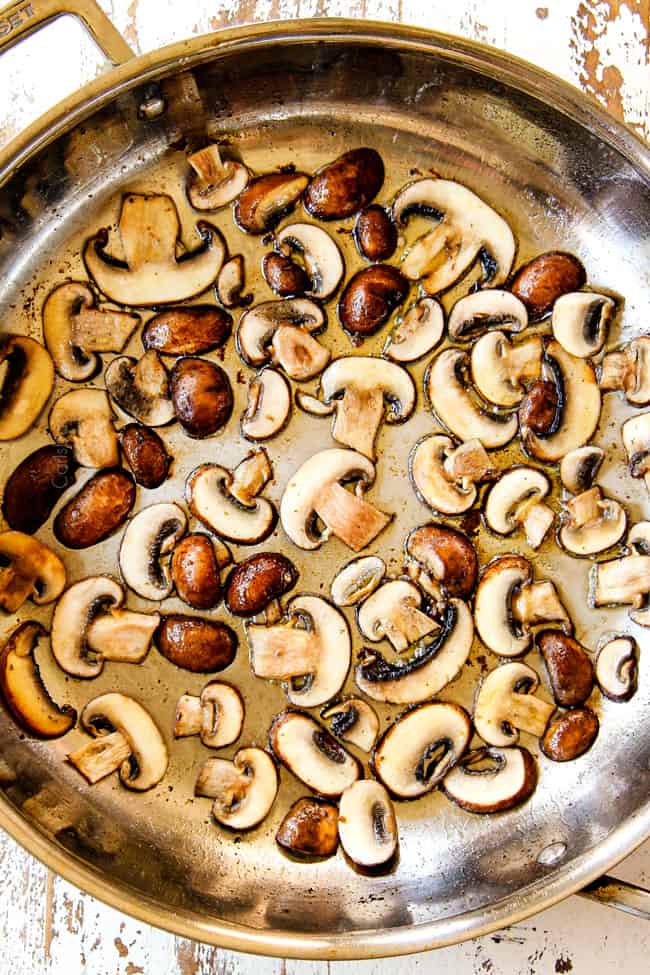 showing how to make mushroom pasta by adding cremini mushrooms in a single layer to a stainless steel skillet