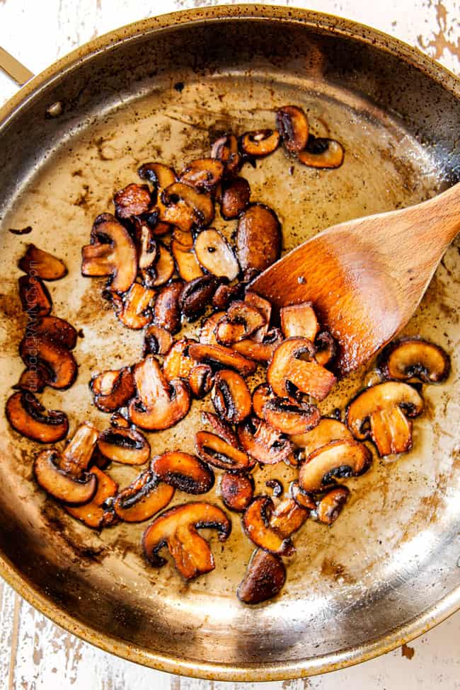 showing how to make mushroom pasta by cooking mushrooms in a stainless steel skillet unto golden brown