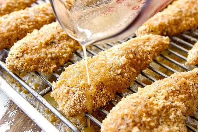 showing how to make baked Parmesan crusted chicken recipe by drizzling chicken tenders with butter