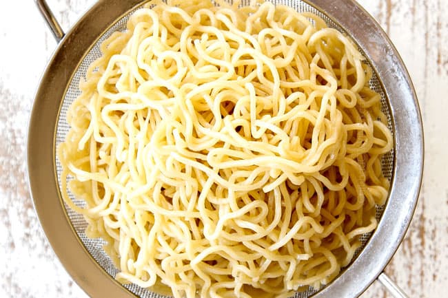 showing how to make yakisoba by draining yakisoba noodles after separating in hot water