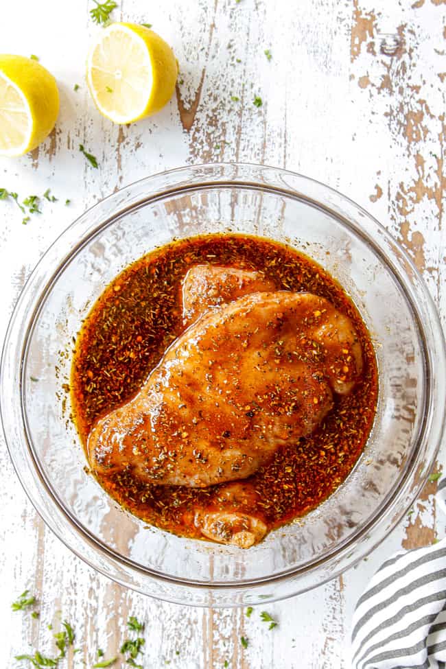 top view of showing how to make grilled chicken marinade by adding chicken breasts to a glass bowl with marinade