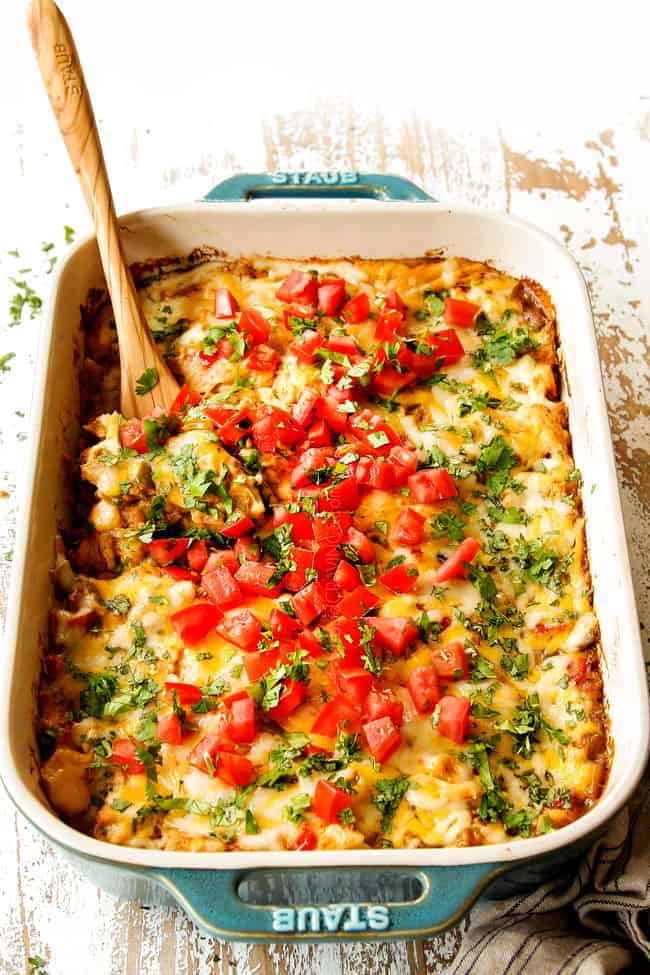 front view of view of King Ranch Chicken Casserole recipe in a 9x13 teal pan garnished by tomatoes and cilantro