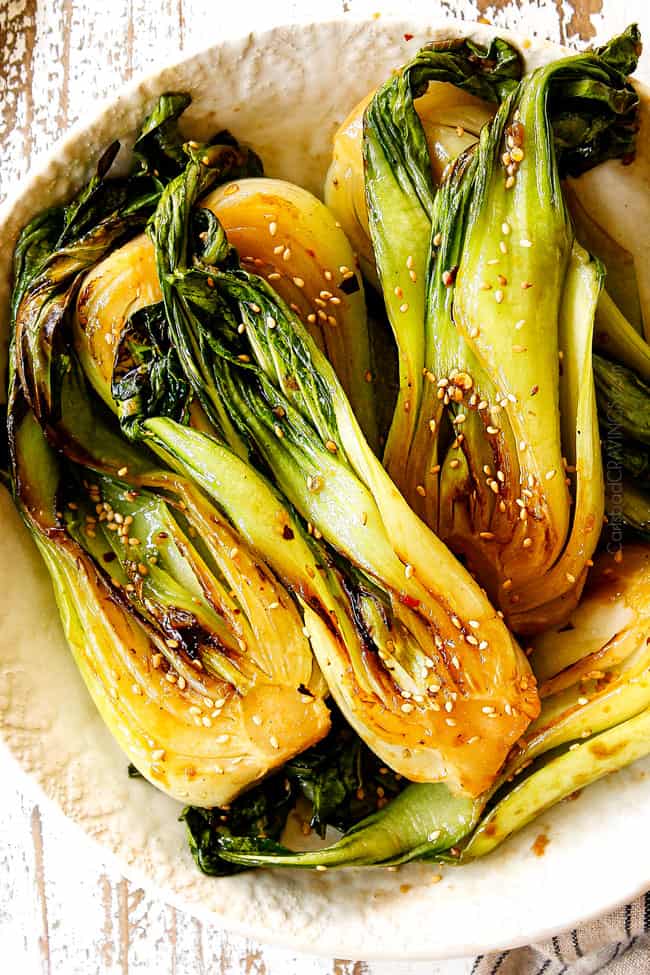 top view of bok choy recipe garnished by sesame seeds in a white bowl