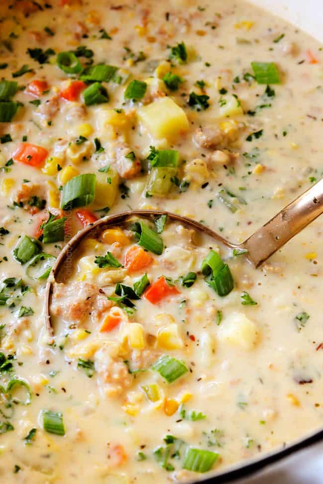 up close of easy corn chowder in a white soup pot being scooped up with a ladle