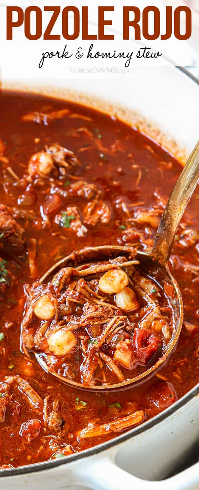 up close of a ladle of pozole rojo in a white Dutch oven