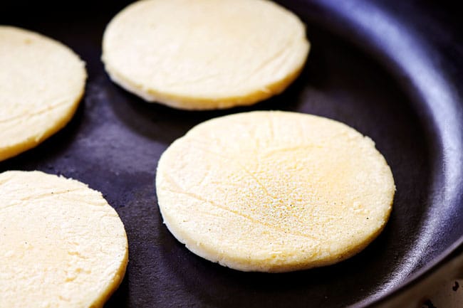 showing how to make sopes recipe by toasting sopes in a cast iron skillet