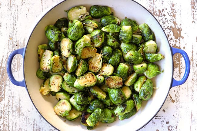showing how to make creamy Brussel sprouts with bacon by sautéing Brussels sprouts with shallots in a pan 