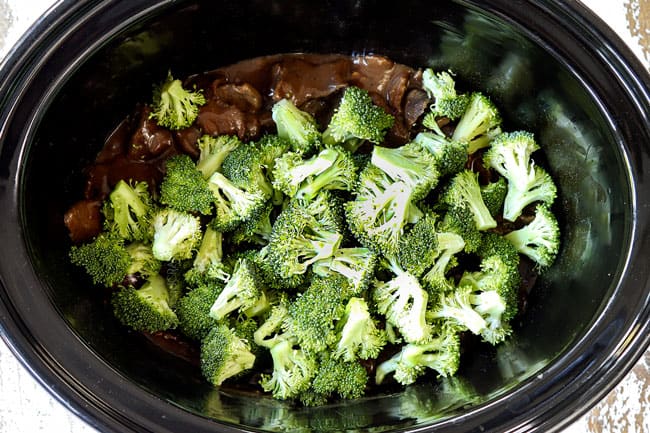 showing how to make crockpot beef and broccoli recipe by adding broccoli to the crockpot