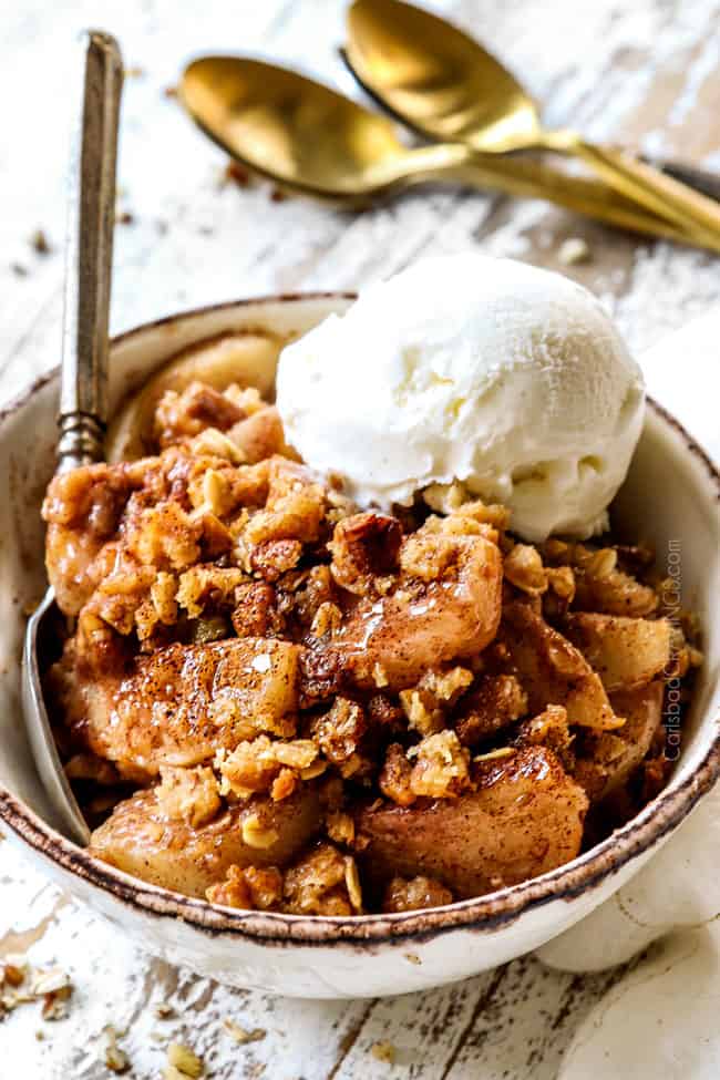 a bowl full of pear crisp with a scoop of vanilla ice cream