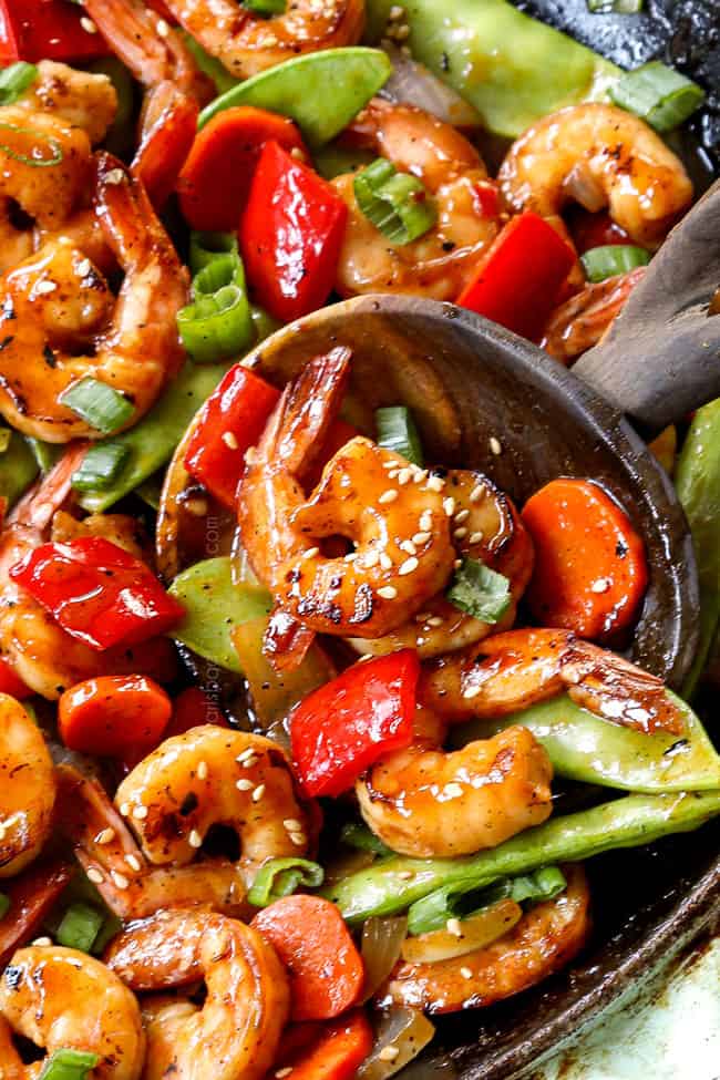 up close of a spoon scooping up shrimp stir fry