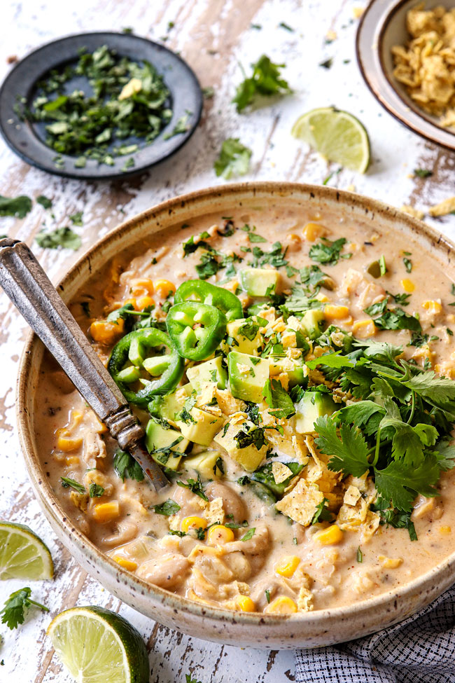 a spoon sitting in a bowl of white bean chicken chili showing how creamy it is
