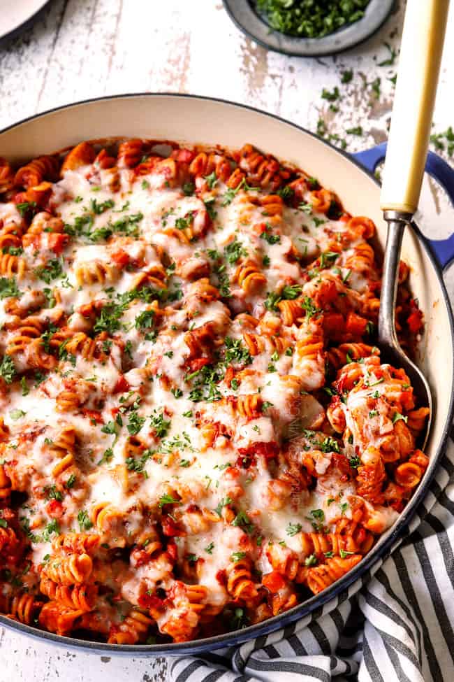 chicken Parmesan pasta smothered in mozzarella cheese and garnished with parsley