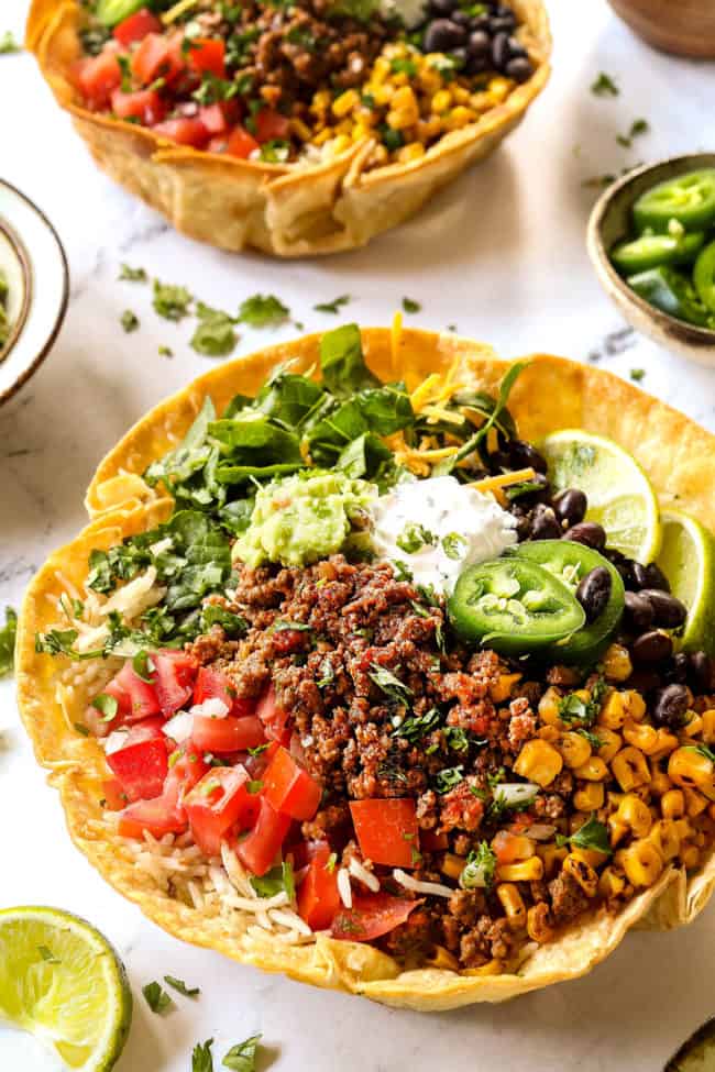 taco bowls in a taco shell with ground beef, corn, tomatoes and black beans