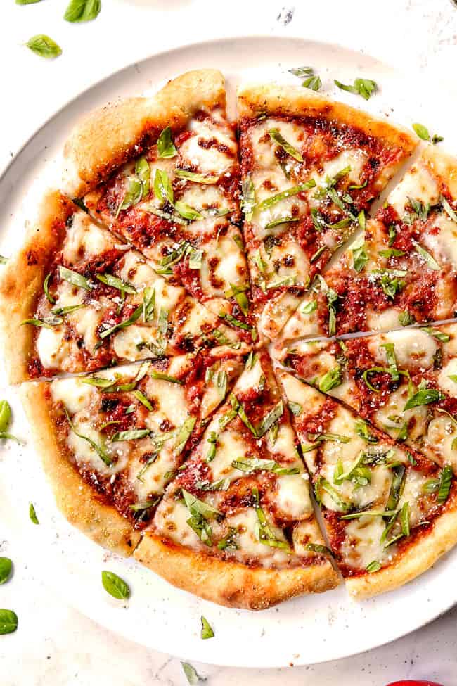margherita pizza by adding pizza sauce, fresh mozzarella, fresh basil and Parmesan to pizza