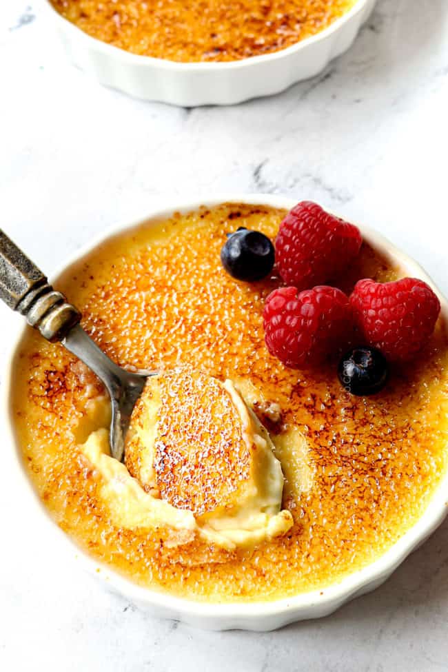 a spoon taking a bite of crème brûlée showing how creamy it is