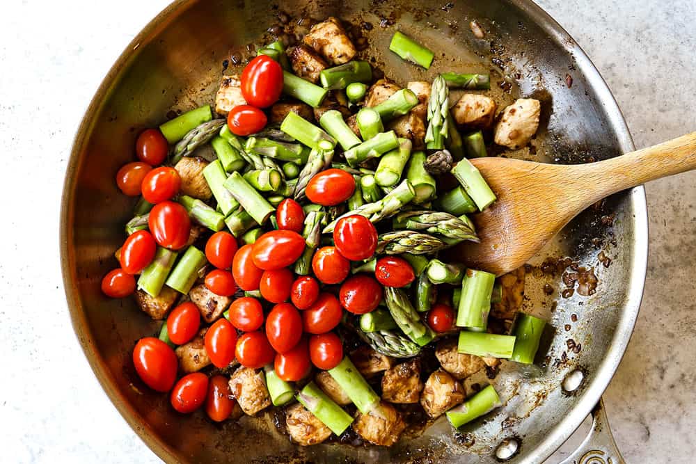 howing how to make balsamic chicken by adding asparagus and tomatoes to the balsamic chicken