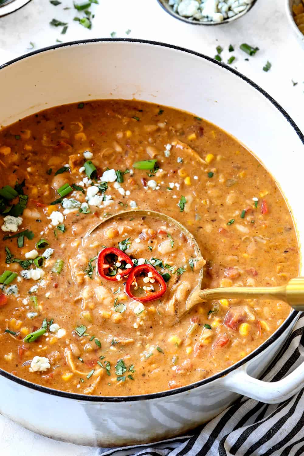 a ladle scooping up buffalo chicken chili showing how creamy it is