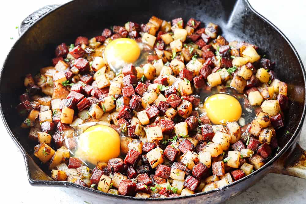 showing how to make corned beef hash with eggs by cracking eggs in the hash before putting in the oven
