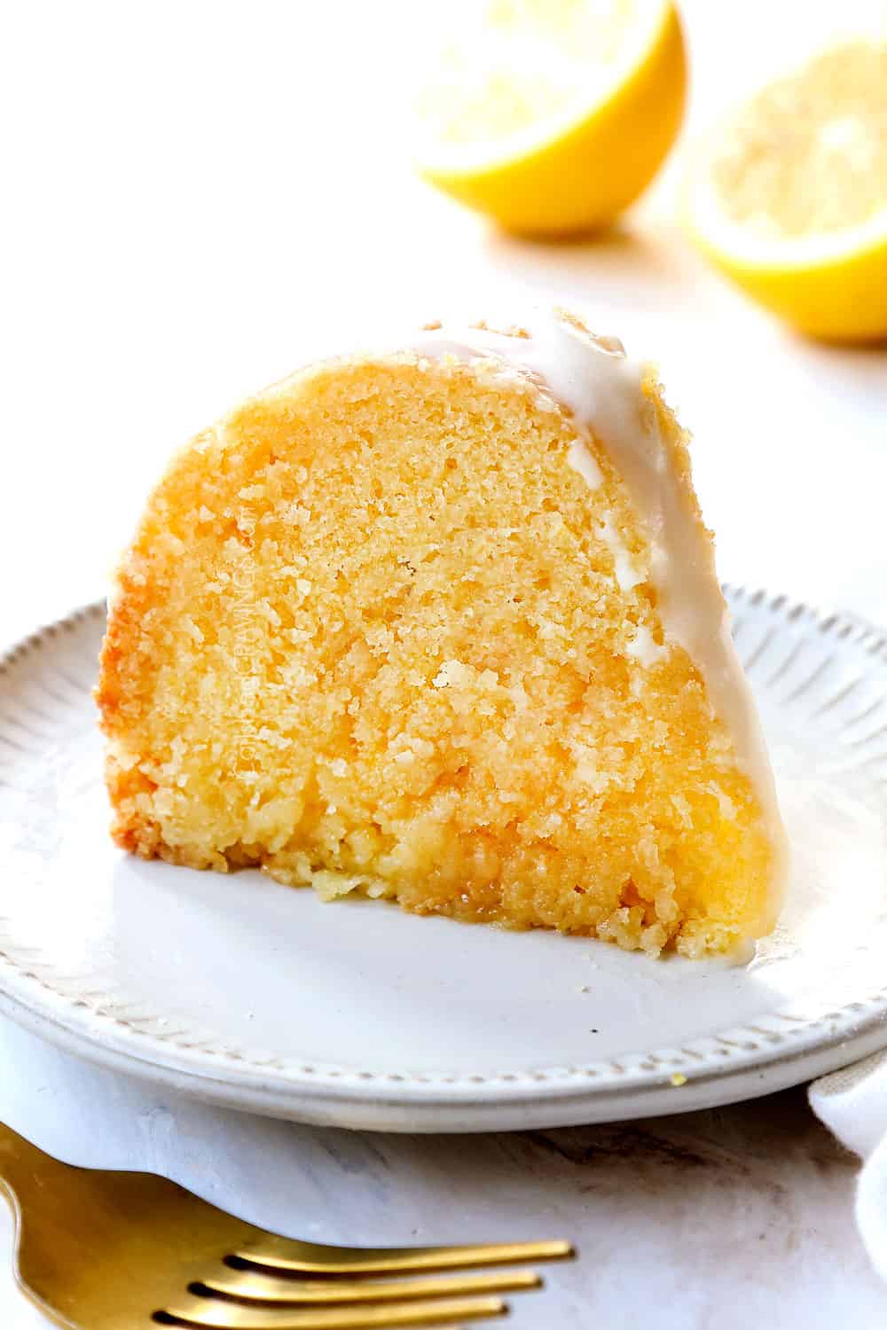 up close of a slice of lemon pound cake on a white plate with lemon glaze for cake
