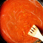showing how to make fideo by adding fideo pasta to tomato sauce in skillet