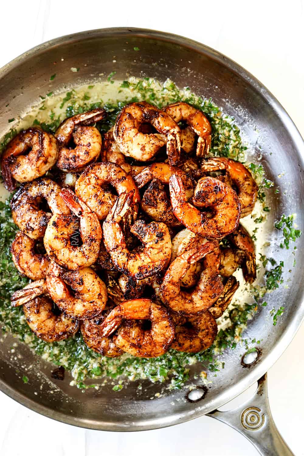 showing how to make easy cilantro lime shrimp recipe by adding shrimp to cilantro lime butter sauce and tossing to combine