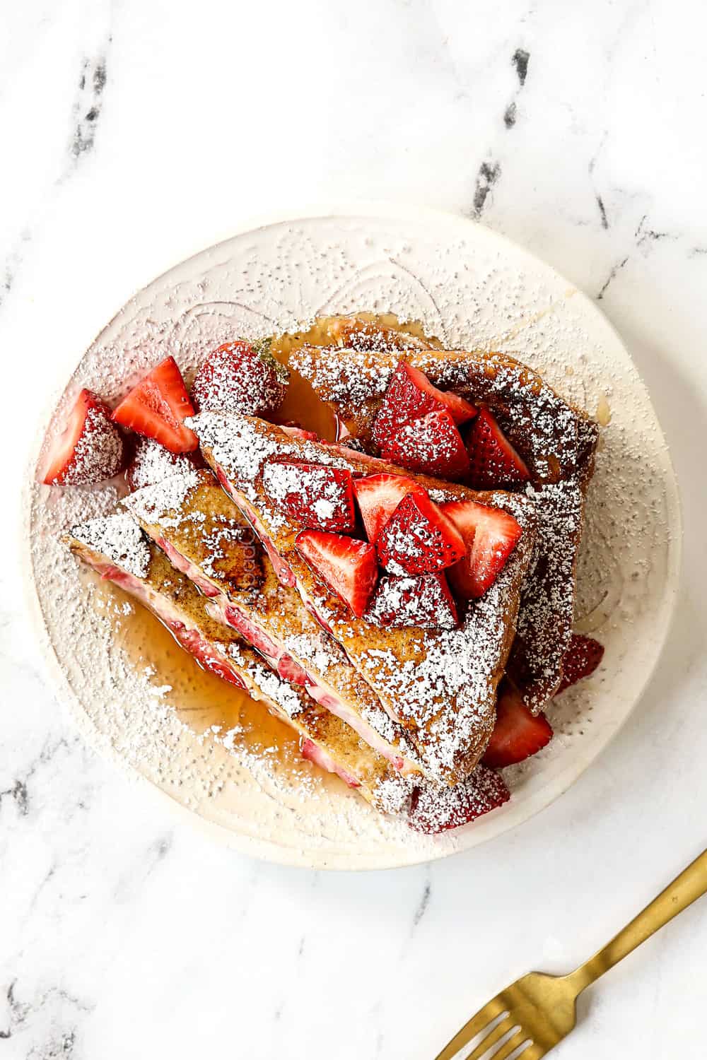 top view of stuffed French toast recipe on a white plate dusted with powdered sugar 