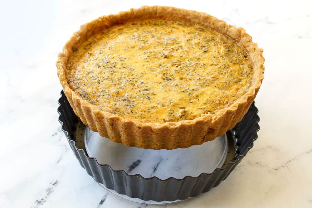 showing how to make Quiche Lorraine recipe by removing baked quiche from quiche pan