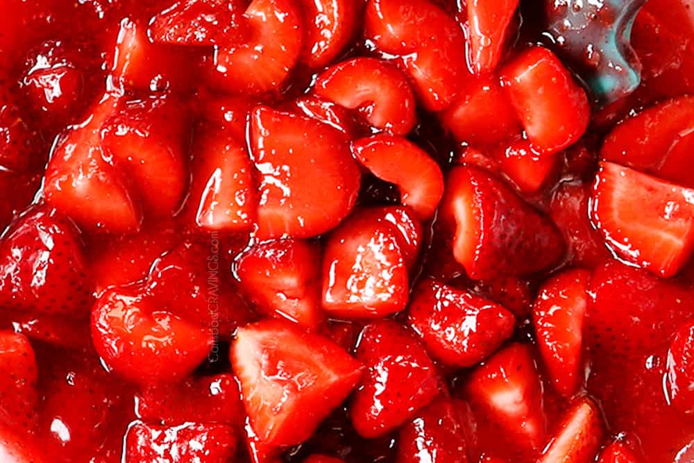showing how to make fresh strawberry pie recipe by adding strawberries to glaze to make strawberry pie filling
