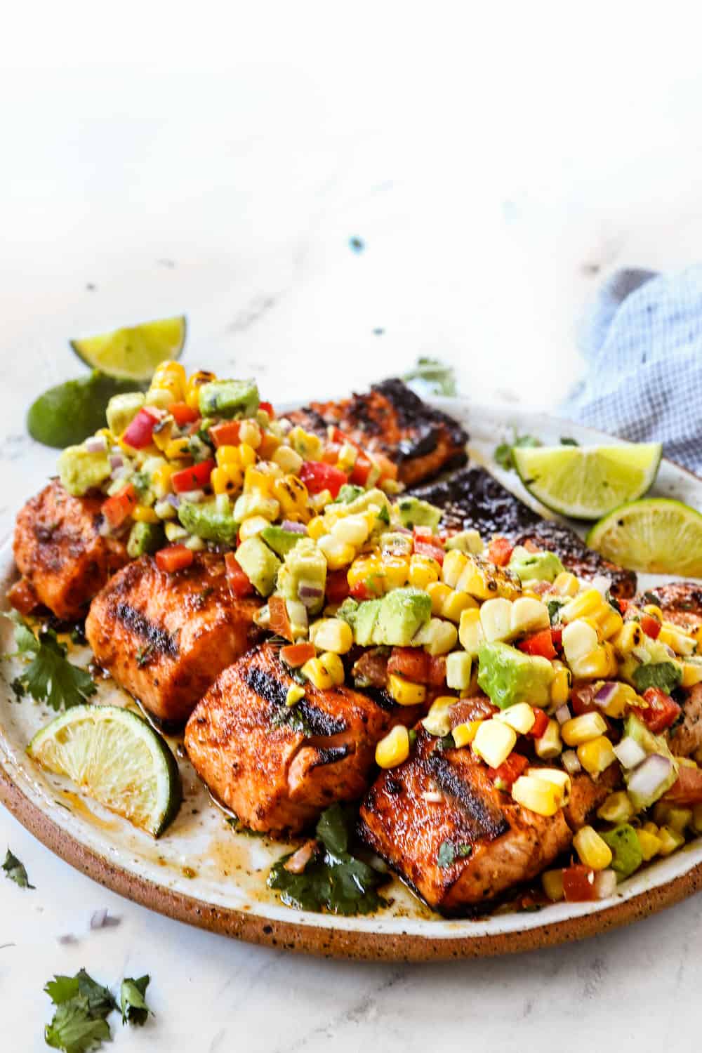showing how to make grilled salmon by topping with avocado salsa