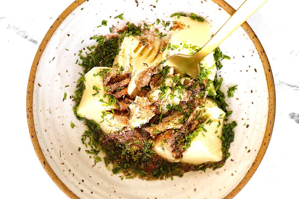 showing how to grill steak by whisking butter and herbs together in bowl