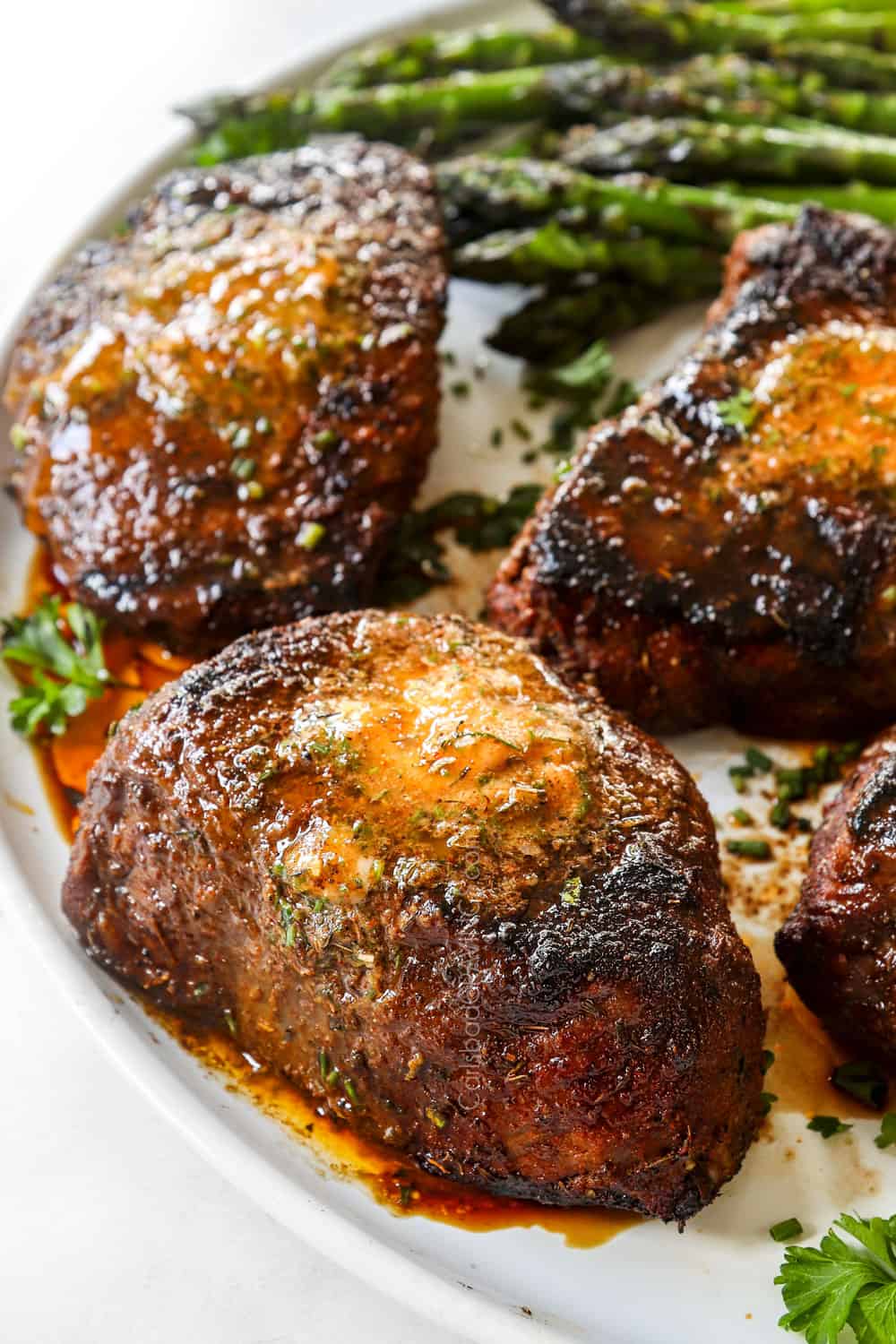 up close of grilled sirloin steak on a white platter showing how tender it is