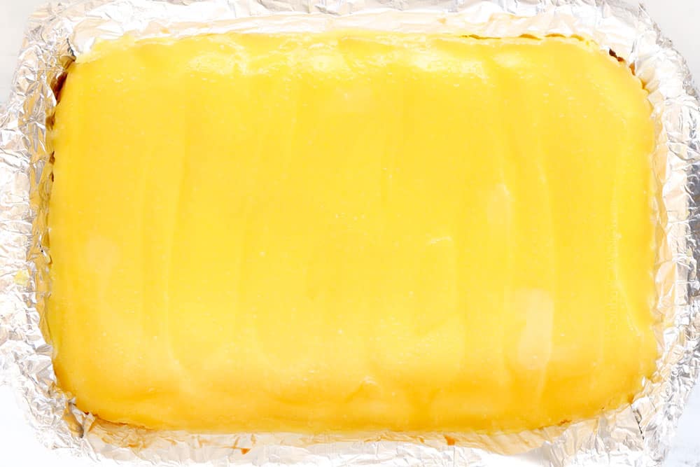 showing how to make lemon cheesecake bars by chilling cheesecake