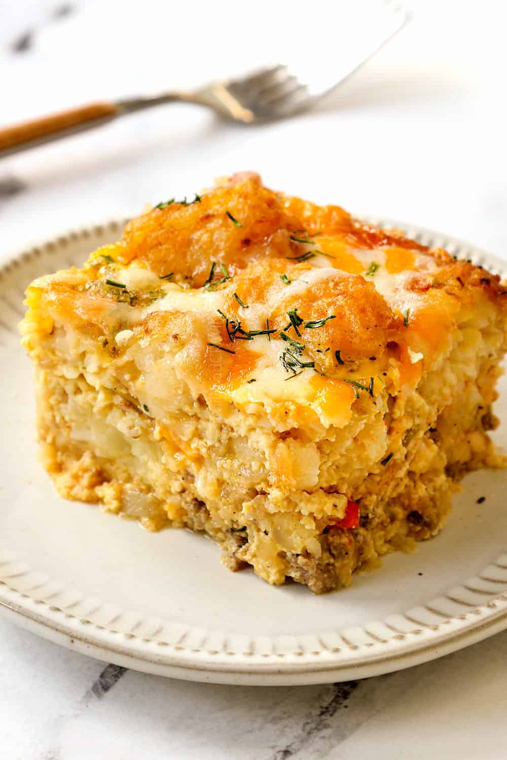 up close of a slice of tater tot breakfast casserole with sausage