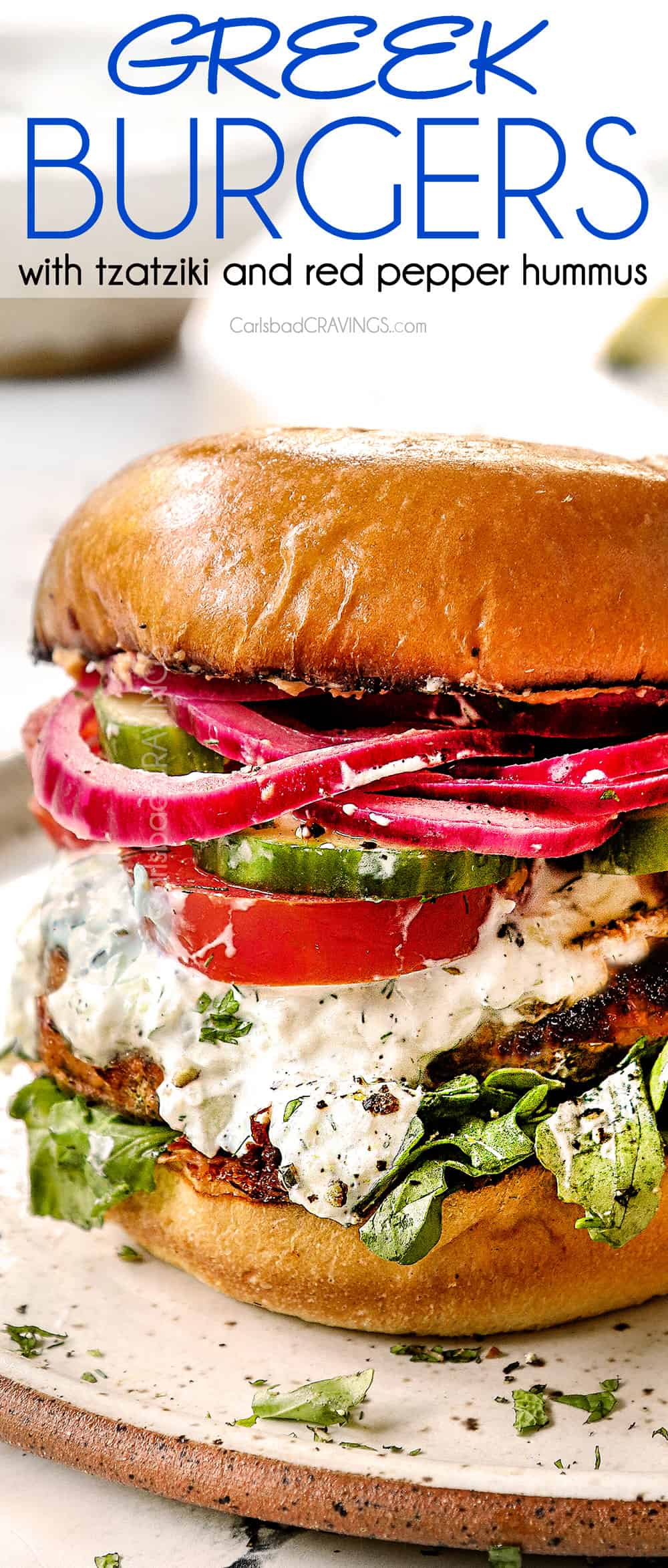 up close of Greek lamb burger recipe with tzatziki, tomatoes, cucumbers and onions