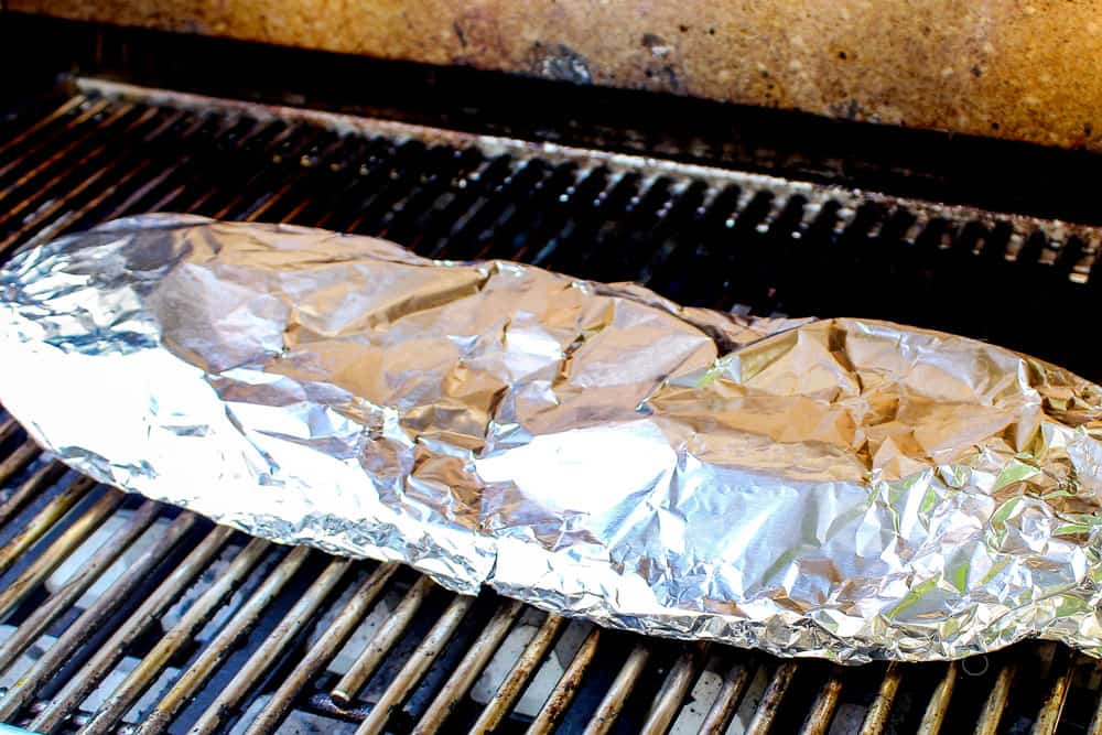 showing how to make grilled salmon in foil by grilling salmon on a gas grill