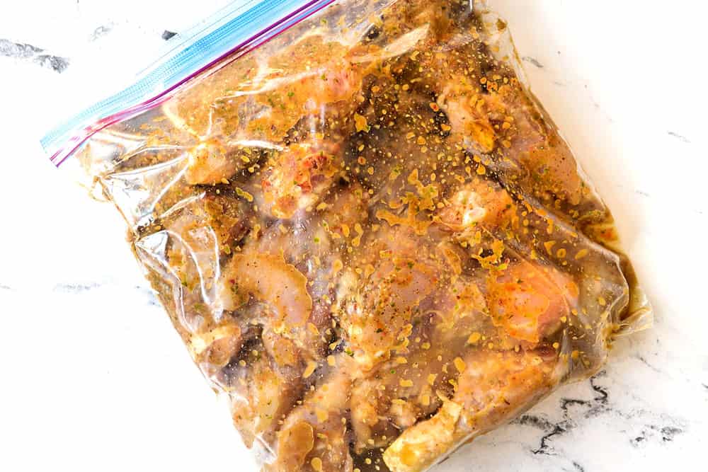 showing how to make Jerk Chicken Recipe by adding marinade and chicken to a ziploc bag and turning to coat the chicken in the marinade