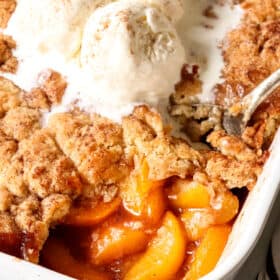up close of scooping easy peach cobbler with fresh peaches