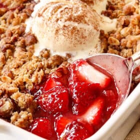 up close of a spoonful of strawberry crumble (crisp) showing the juicy strawberry filling