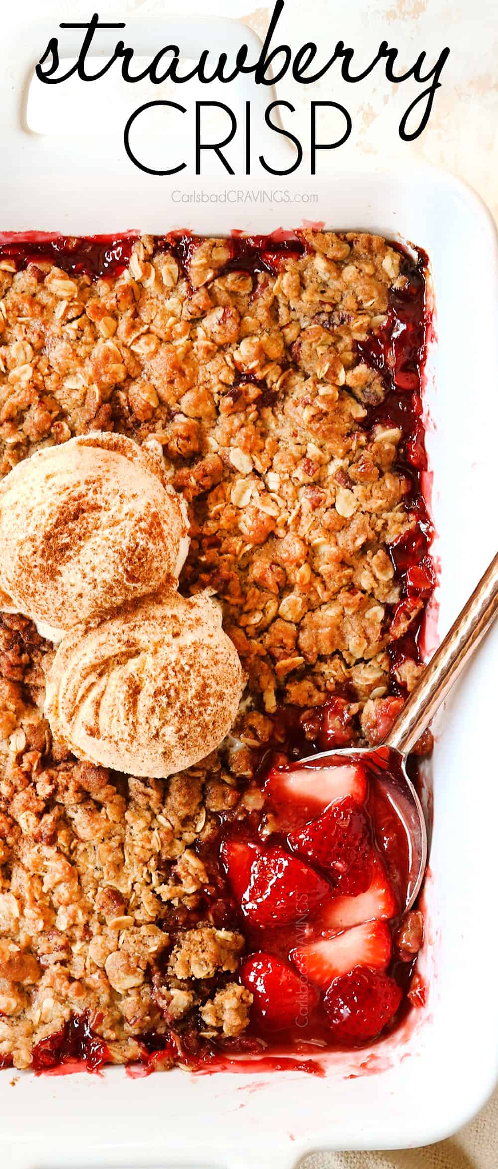 up close top view of strawberry crisp recipe topped with vanilla ice cream with a serving spoon