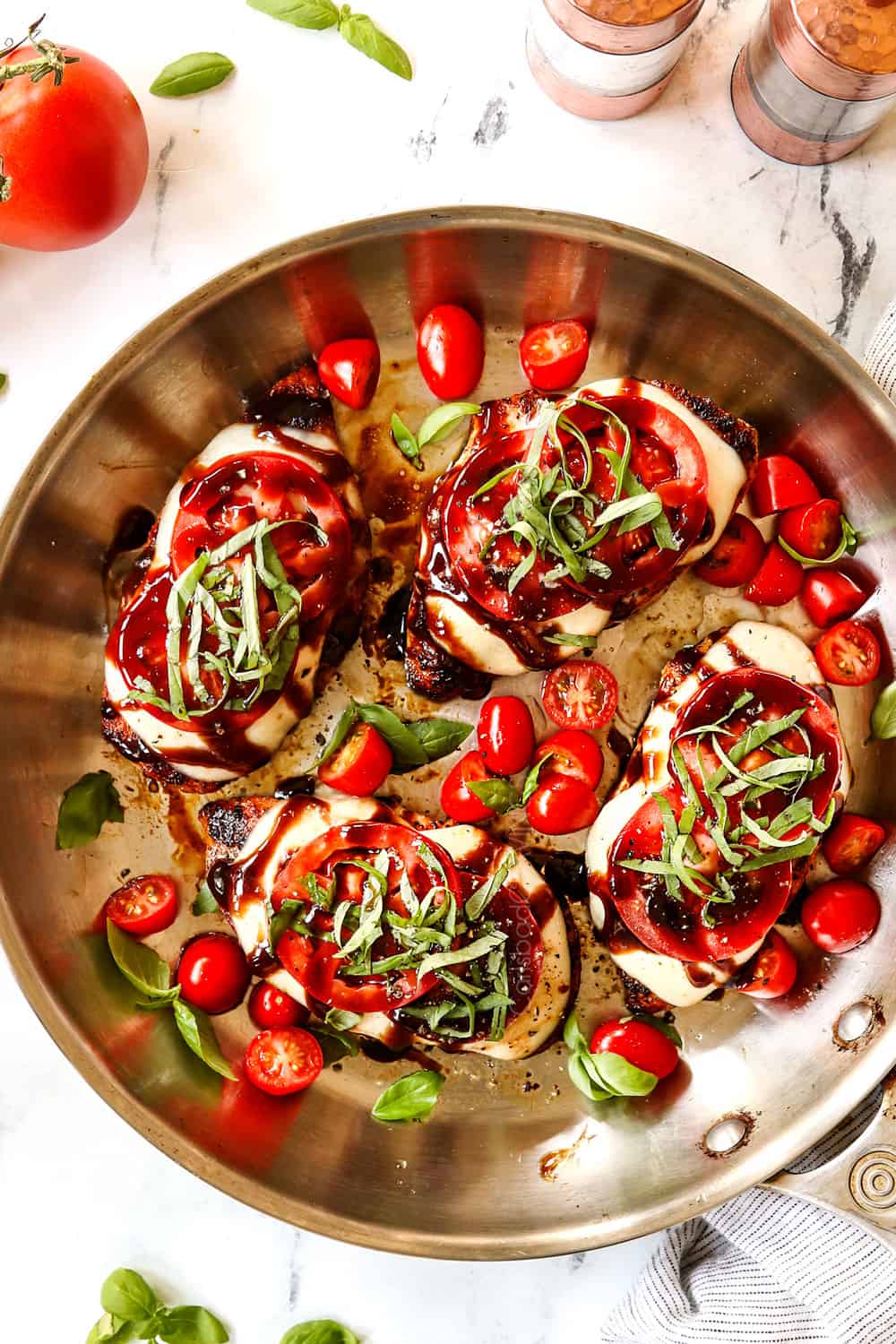 top view of chicken caprese recipe in a stainless steel skillet