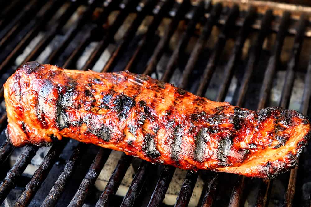 showing how to make marinated pork tenderloin by grilling pork on a hot grill