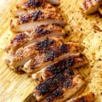blackened chicken on a cutting board sliced into strips showing the charred crust