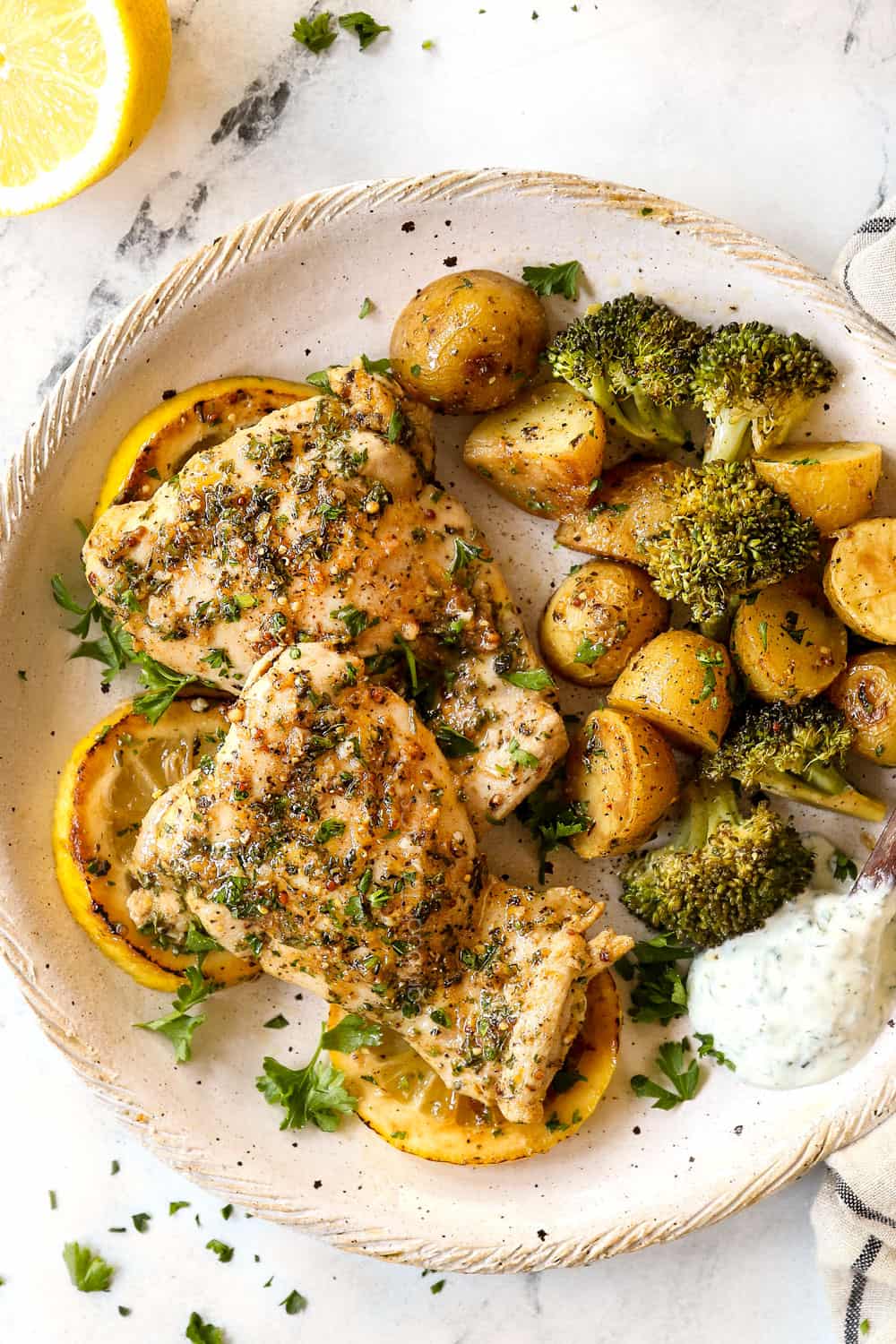 top view of lemon garlic chicken things on a plate with potatoes and broccoli