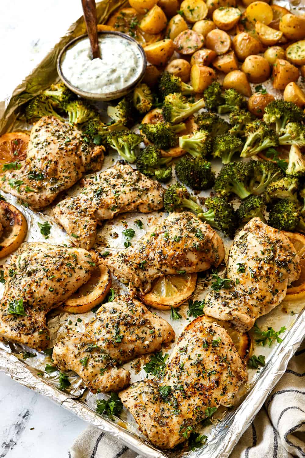 lemon garlic chicken thighs on a sheet pan with broccoli and potatoes