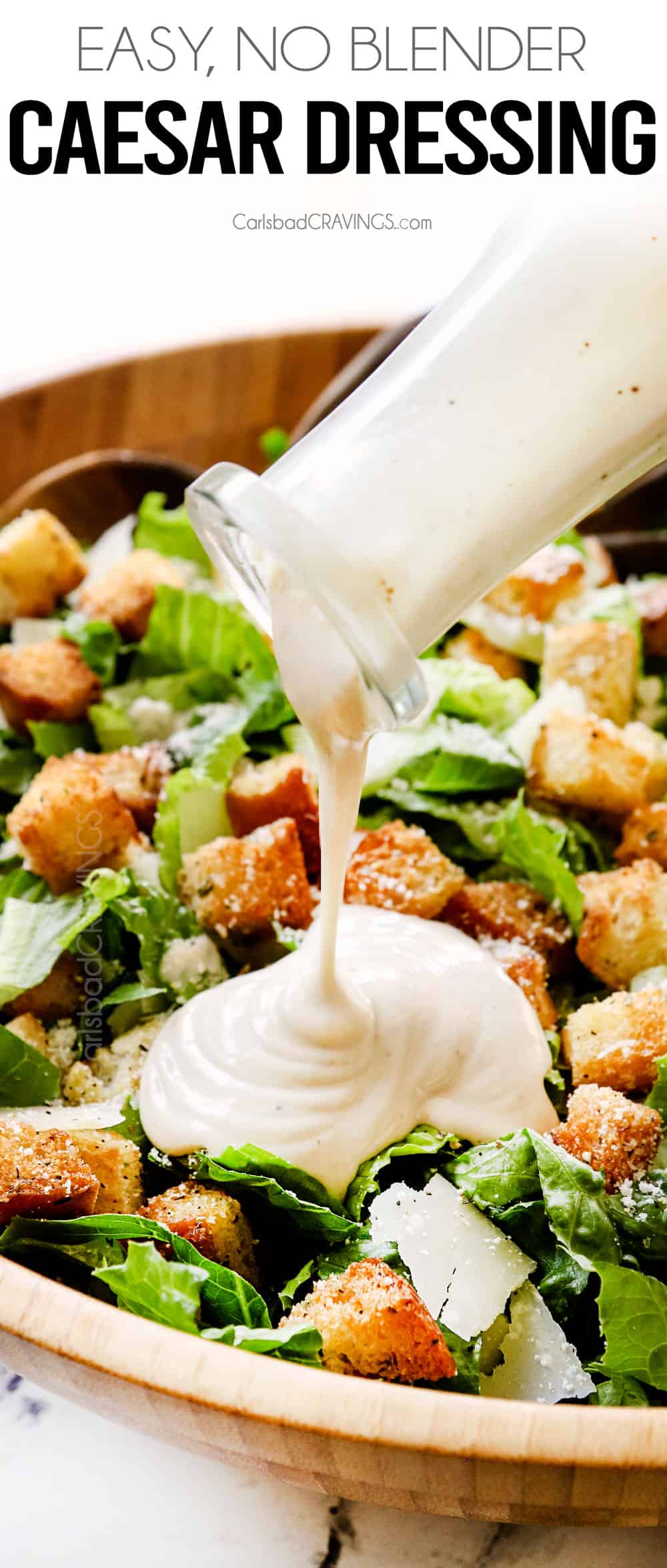 pouring Caesar dressing of salad with croutons and Romaine lettuce