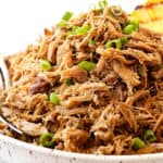 a bowl of Kalua pork recipe garnished with green onions