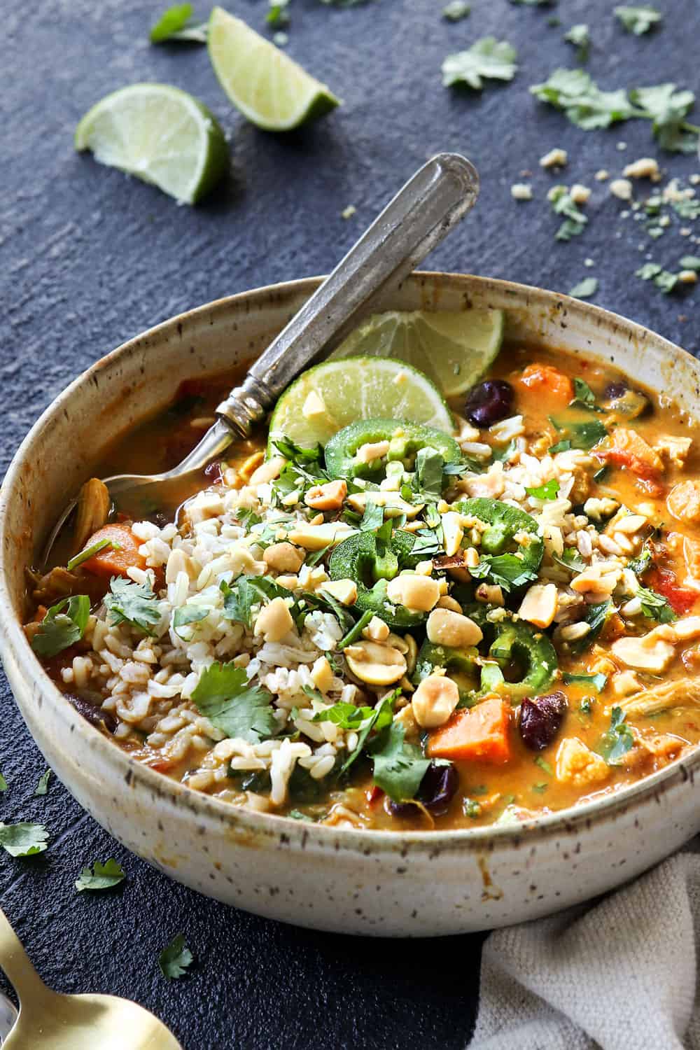 showing how to serve African Peanut Stew by topping with rice, cilantro, peanuts and lime juice