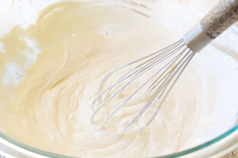 showing how to make French Onion Dip recipe by whisking together the sour cream and mayonnaise