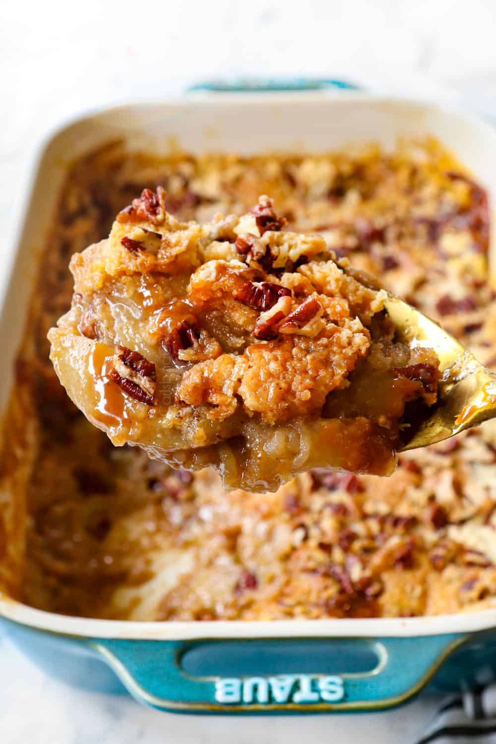 up close of a scoop of apple dump cake recipe with apples, cake mix, butter and pecans