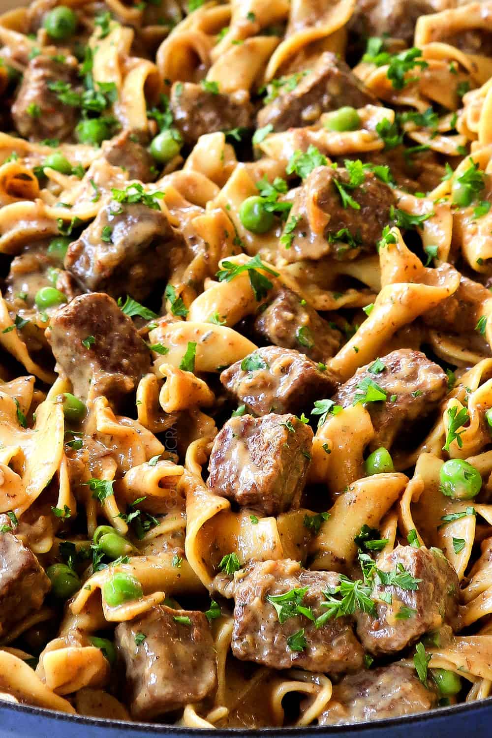 up close of beef tips and noodles in a pan showing how creamy it is
